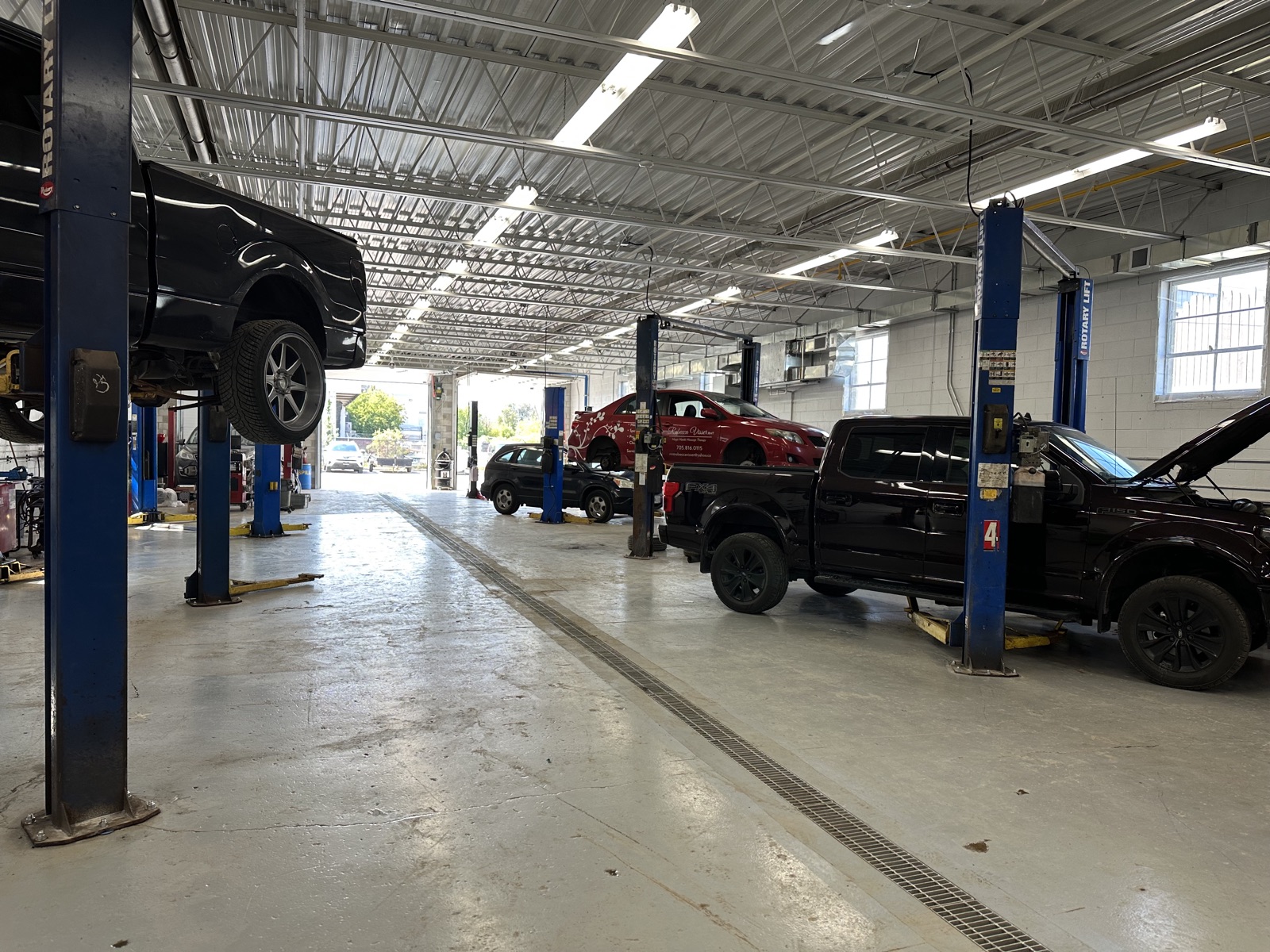 Trucks and cars on hoists inside Barrie AutoCare Centre's new 10-bay garage